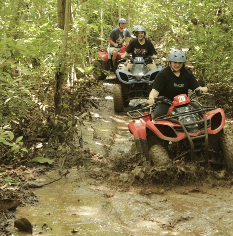 Quad bikes on a muddy track through the trees behind Uluwatu